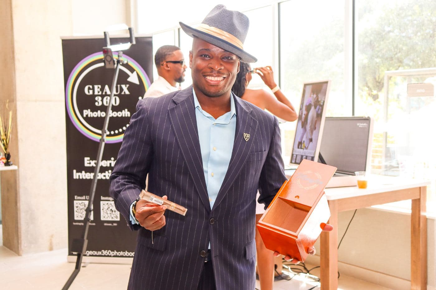 A guest in a navy pinstripe suit and straw hat