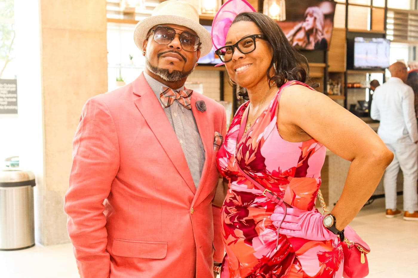 Two guests in coral tailoring and a patterned scarf