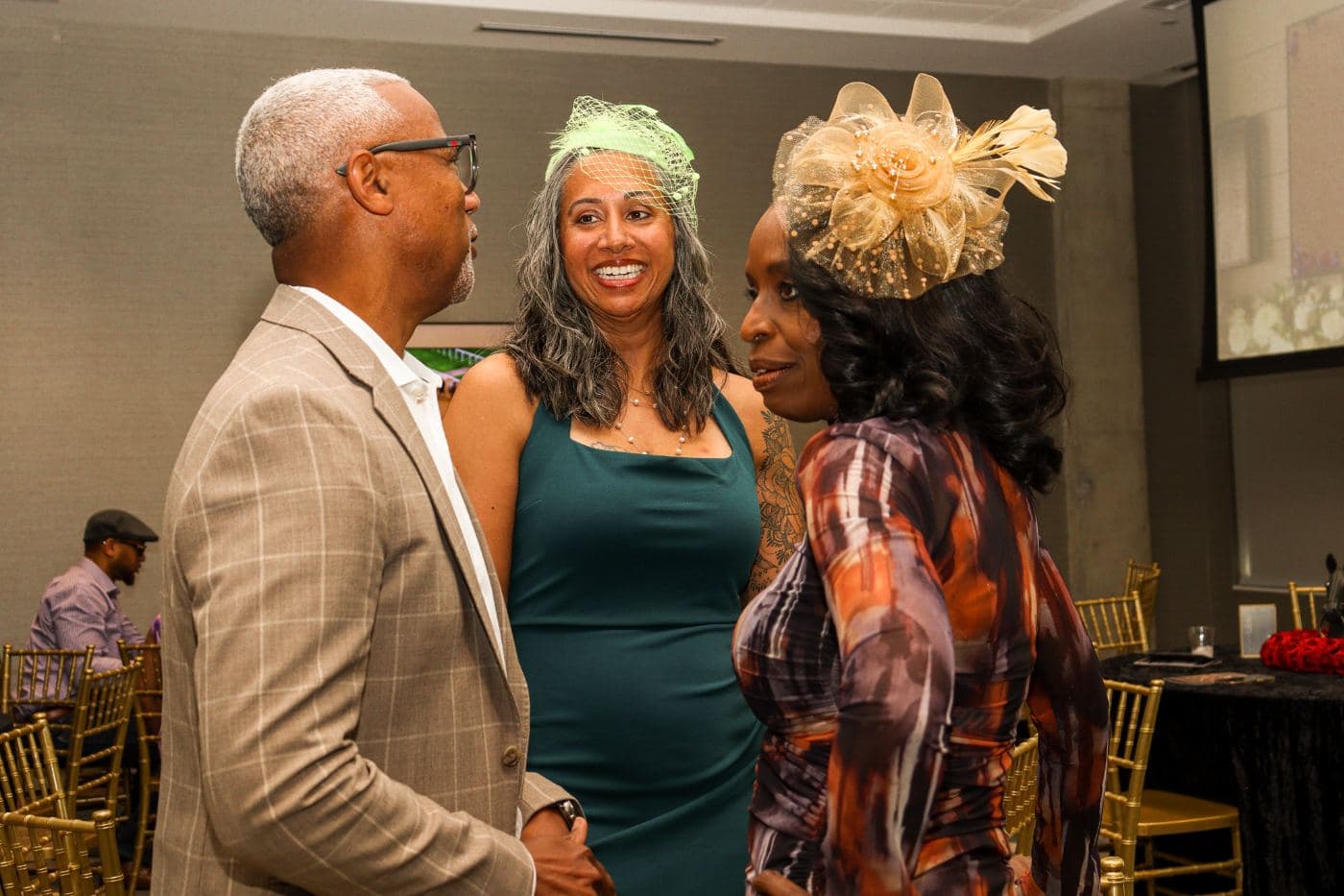 Three guests in evening green and hats